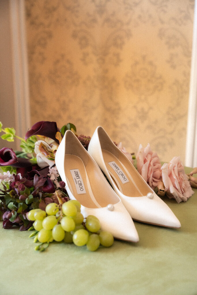 photos of white sating Jimmy Choos with bridal bouquet and grapes shot by editorial wedding duo young plant weddings