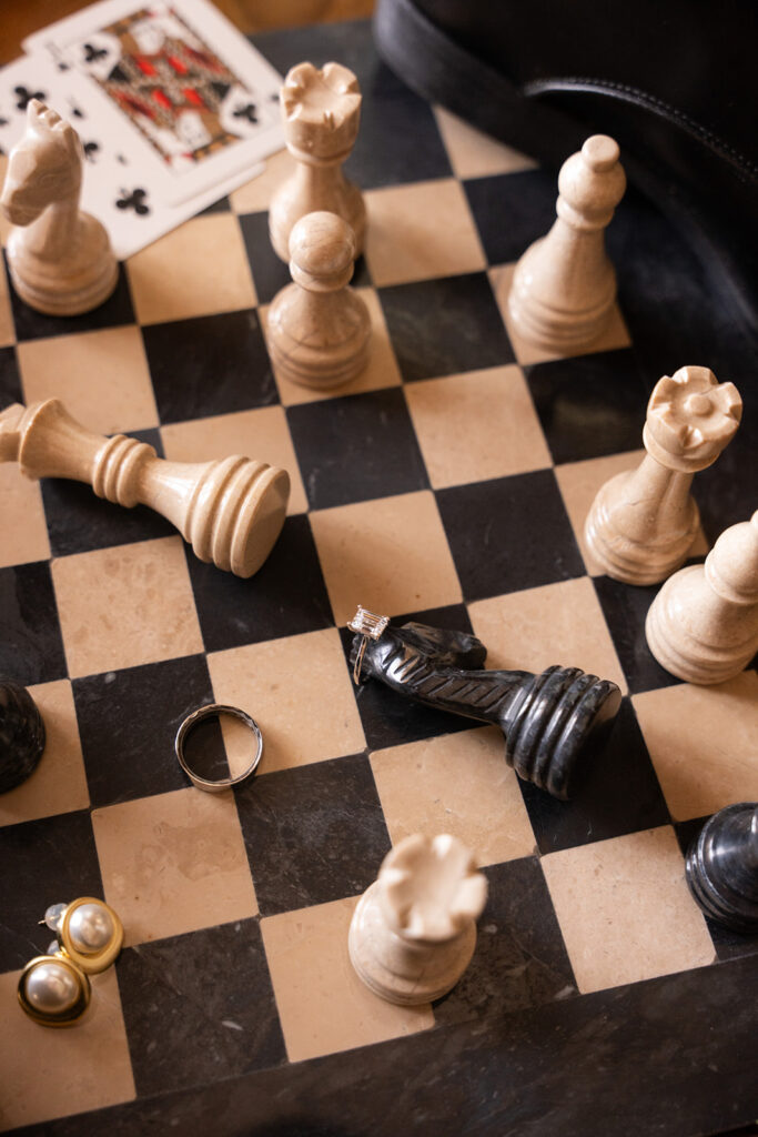 chess set with brides earrings and wedding bands messy shot by editorial wedding duo young plant weddings