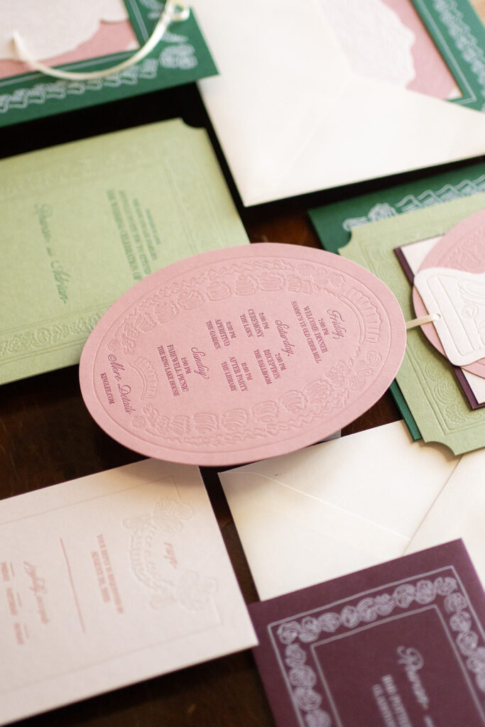 Flat lay of modern wedding invitation suite by The Gold Edit, featuring layered paper elements, abstract shapes, and neutral tones.