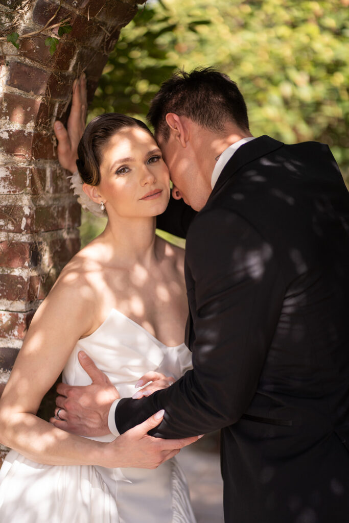 close up of bridal makeup while groom is leaning into her neck for a kiss