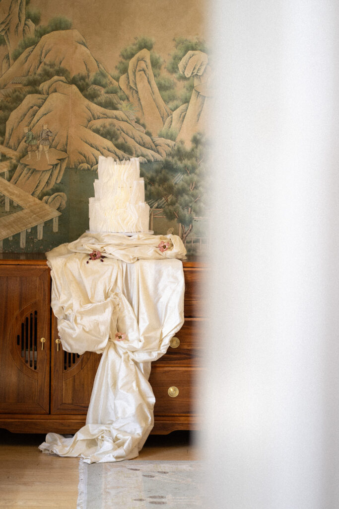 cake displayed on ruffled fabric in gorgeous european inspired wedding editorial
