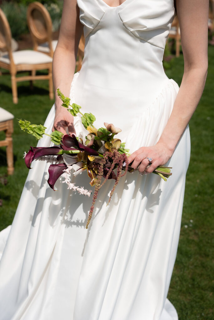 bride holds bouquet in front of her dress styled by Wild Blooms NJ a wedding florist in New Jersey